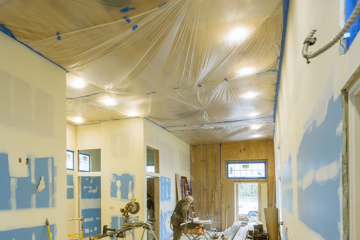 Een renovatie met nieuwe gyprocwanden, een vakman zaagt planken op maat